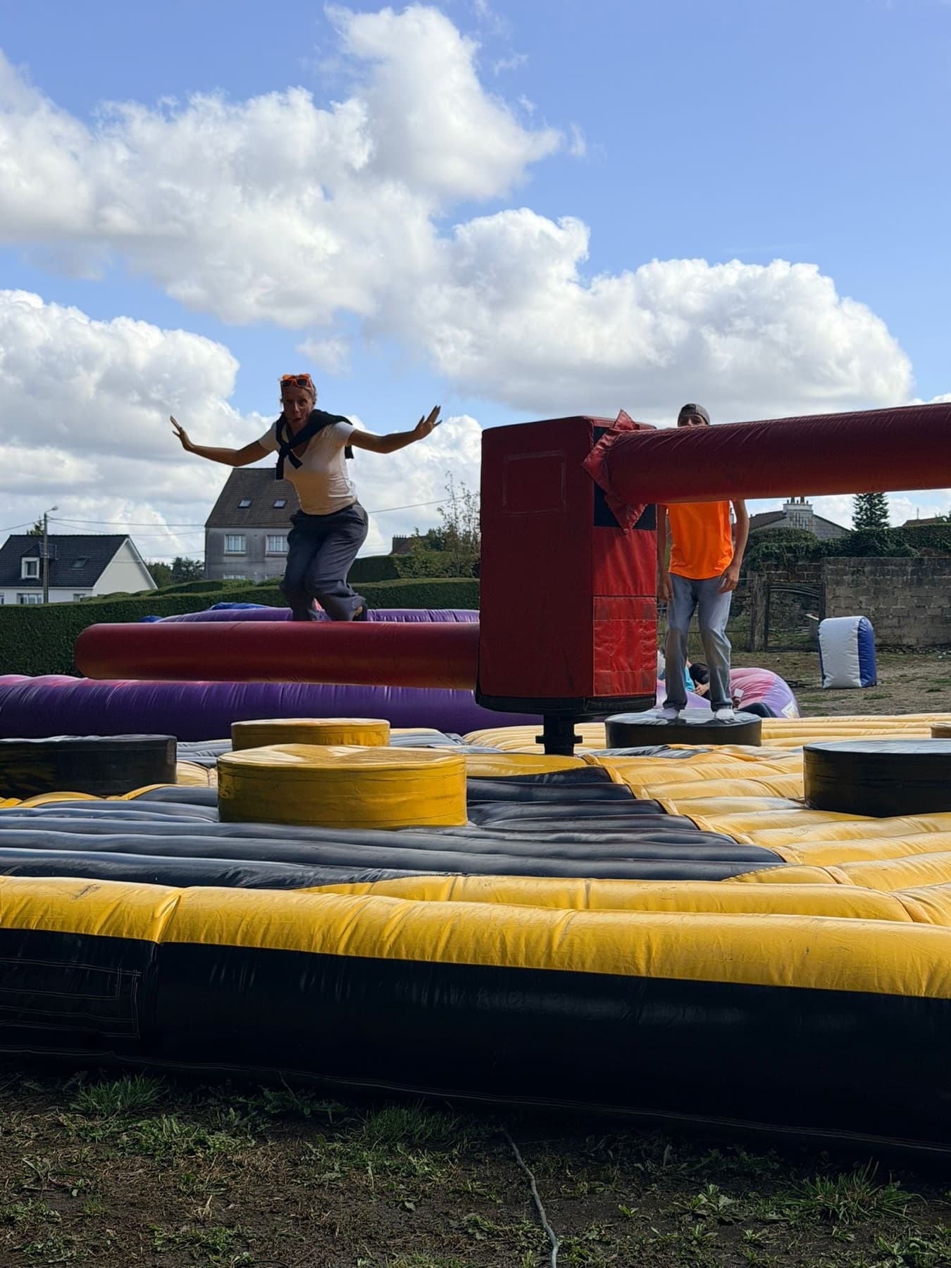 Participante sautant au-dessus d'une barre tournante sur un parcours gonflable.