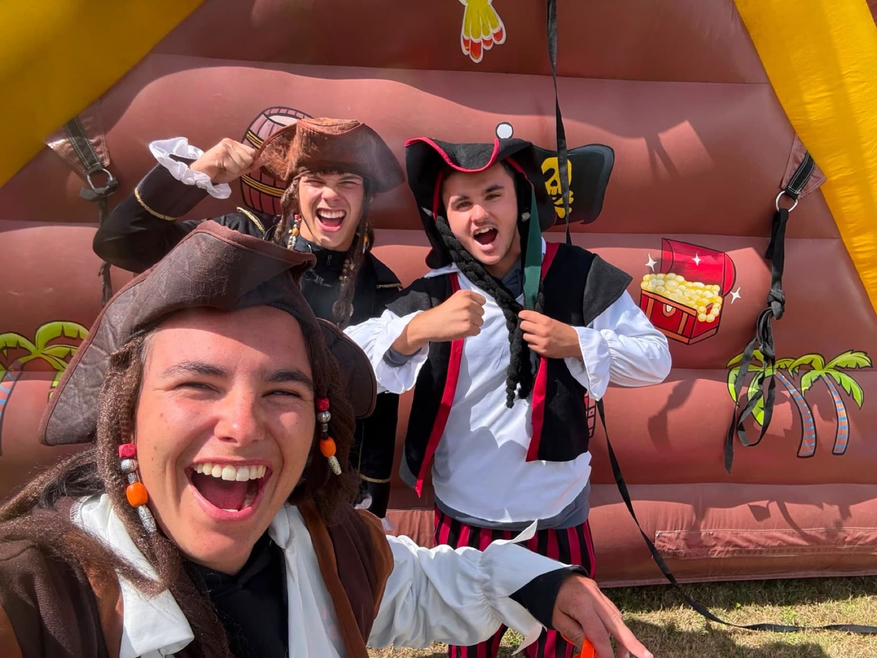Groupe déguisé en pirates devant une structure gonflable à thème.
